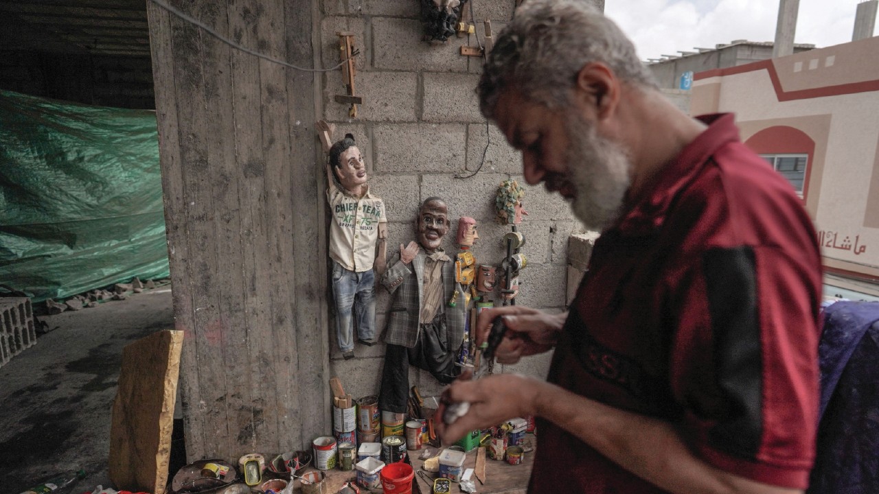 Palestinian Mahdi Karira works on a puppet at his workshop in Deir el-Balah, in the central Gaza ...