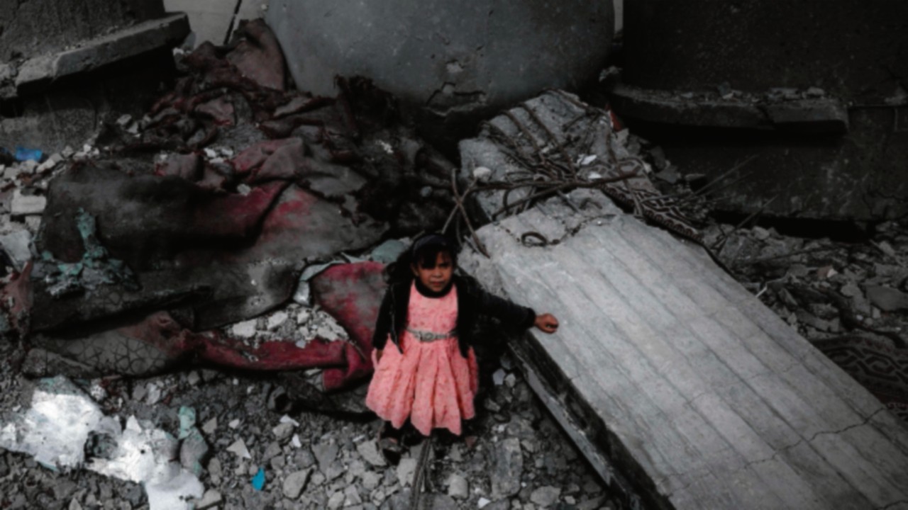 TOPSHOT - A Palestinian girl wearing a pink dress stands amidst the ruins of the Al-Faruq Mosque ...