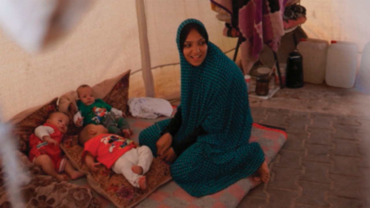 TOPSHOT - A Palestinian mother and her triplets shelter in their tent at a displacement camp in Deir ...