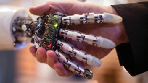A visitor holds a hand of AILA, or Artificial Intelligence Lightweight Android, during a ...