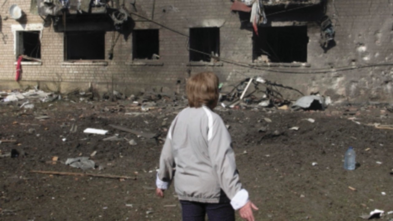 epa11333857 Tetyana looks at a building damaged during recent shelling on the outskirts of Volchans, ...