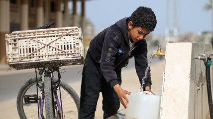 A Palestinian boy fills a container with water from a public tap On World Water Day, a United ...