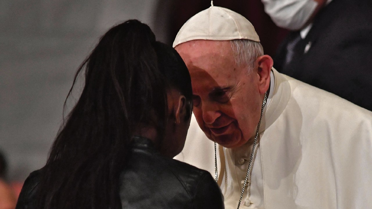 Pope Francis (R) greets a woman during an ecumenical prayer with migrants at the Roman Catholic ...