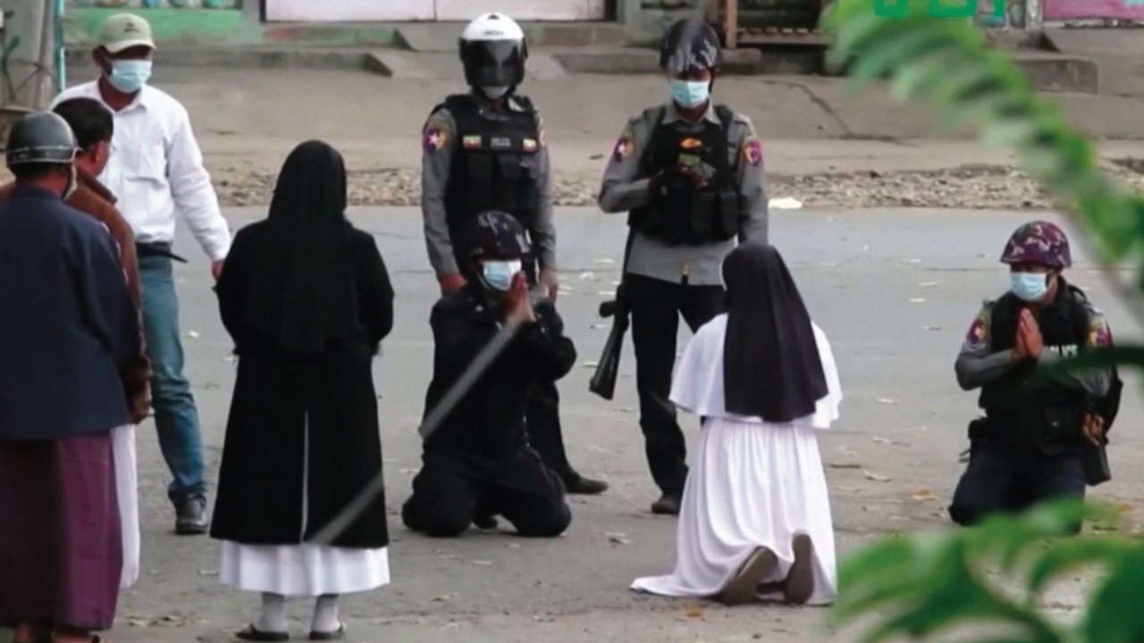 Myanmar nun Sister Ann Rose Nu Tawng kneels in front of police officers to ask security forces to ...