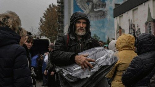 People take blanket and light during an aid supply distribution in the centre of Kherson on November ...