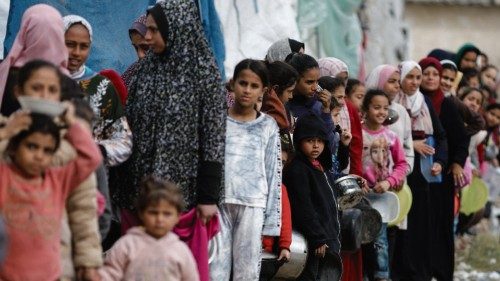 Palestinians stand in a line as they wait to receive food amid shortages of food supplies, amid the ... Palestinians stand in a line as they wait to receive food amid shortages of food supplies, amid the ...
