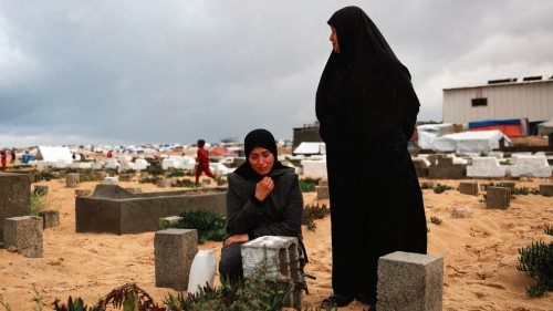 A woman cries over the grave of a loved one at the start of the Eid al-Fitr festival, marking the ...