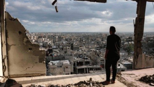 A man standing atop a heavily damaged building views other destroyed buildings in Khan Yunis in the ... A man standing atop a heavily damaged building views other destroyed buildings in Khan Yunis in the ...
