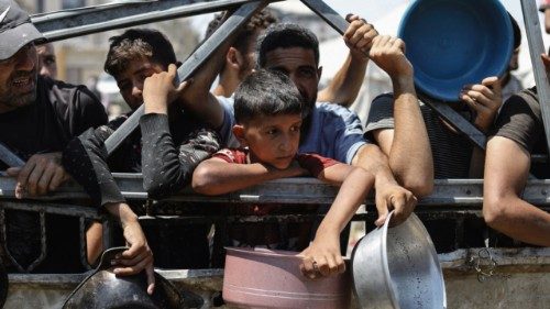 Palestinians wait to receive food from a charity kitchen, amid a hunger crisis, in Gaza City, July ...