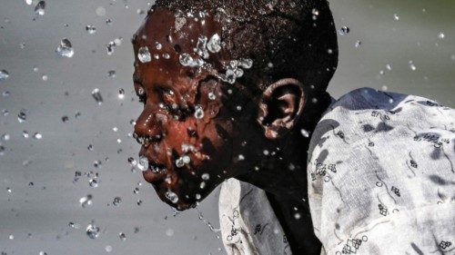 TOPSHOT - A boy splashes himself with water in the Atbarah river near the village of Dukouli within ...