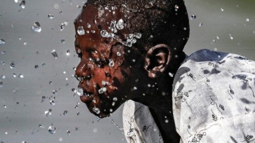 TOPSHOT - A boy splashes himself with water in the Atbarah river near the village of Dukouli within ... TOPSHOT - A boy splashes himself with water in the Atbarah river near the village of Dukouli within ...