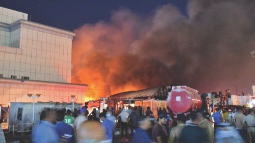 People gather as a massive fire engulfs the coronavirus isolation ward of Al-Hussein hospital in the ...