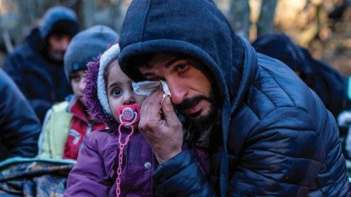 TOPSHOT - A man holding a child reacts as the members of the Kurdish family from Dohuk in Iraq wait ...