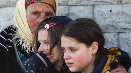 Residents react as they are evacuated from a village retaken by Ukrainian forces, next to a ...