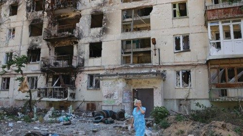 A local resident stands in front of an apartment building heavily damaged during Ukraine-Russia ...