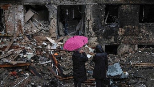 Local residents stand near their building destroyed by a Russian missile attack, as Russia's attack ...