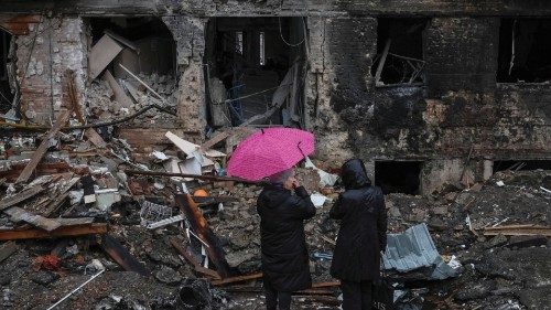 Local residents stand near their building destroyed by a Russian missile attack, as Russia's attack ... Local residents stand near their building destroyed by a Russian missile attack, as Russia's attack ...