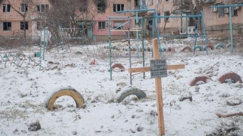 A view shows a grave of a local resident near buildings damaged by a Russian military strike, as ...