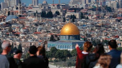 Tourists stand at the Mount of Olives overlooking Jerusalem's Old City and the Dome of the Rock in ...