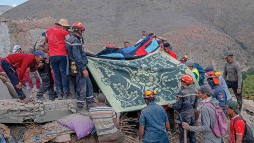 Rescue workers cover a body that was recovered from the rubble of destroyed houses in the village of ... Rescue workers cover a body that was recovered from the rubble of destroyed houses in the village of ...