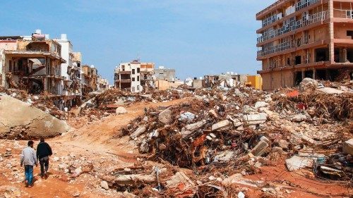 TOPSHOT - Men walk past debris of buildings caused by flash floods in Derna, eastern Libya, on ... TOPSHOT - Men walk past debris of buildings caused by flash floods in Derna, eastern Libya, on ...