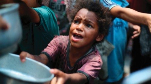 Palestinian children line up to receive a hot meal at a food distribution point in Nuseirat on June ... Palestinian children line up to receive a hot meal at a food distribution point in Nuseirat on June ...