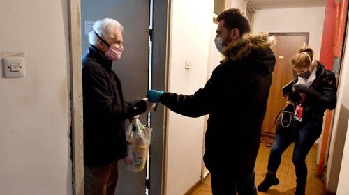 Members of Bosnian volunteer brigade arrive to deliver a small supply of food to an elderly person ...