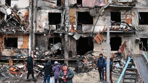 People gather in front of a damaged residential building at Koshytsa Street, a suburb of the ...