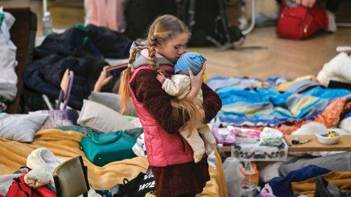 TOPSHOT - A girl holds her sibling in a temporary shelter for Ukrainian refugees in a school in ...