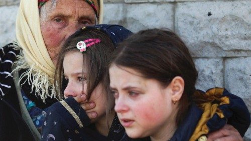 Residents react as they are evacuated from a village retaken by Ukrainian forces, next to a ...