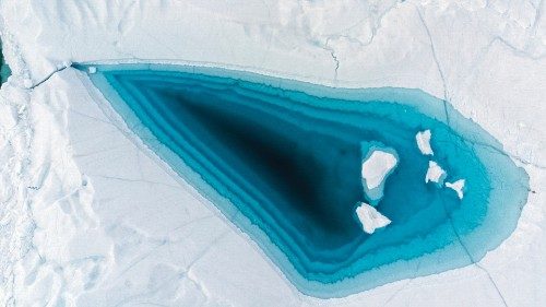 Picture taken on June 29, 2022 with a drone shows turquoise water in a large melt hole on the top of ...