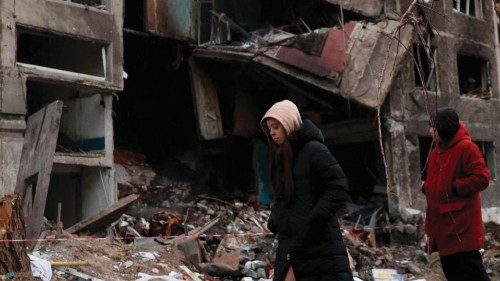 Local residents walk past an apartment building destroyed by a Russian missile attack in the town of ... Local residents walk past an apartment building destroyed by a Russian missile attack in the town of ...