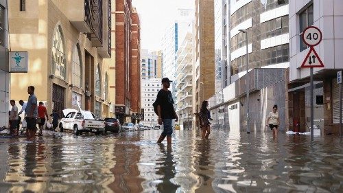 People walk through flood water caused by heavy rains, in Dubai, United Arab Emirates, April 17, ...