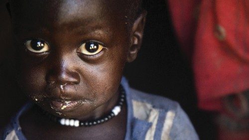 A boy eats out of a ladle at his home in Ngop in South Sudan's Unity State on March 10, 2017. - The ...