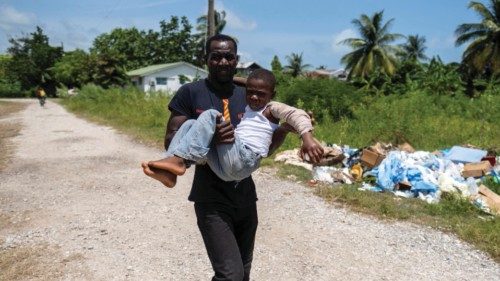 A man carries a boy injured after Saturday's 7.2 magnitude quake to receive medical attention at the ...