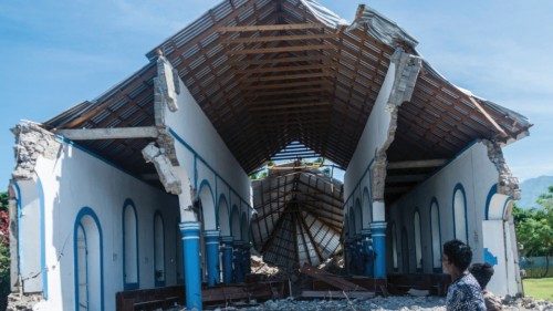 TOPSHOT - Two Haitians walk past a church destroyed during an earthquake in Les Anglais on August ...