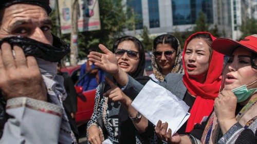 Afghan women converse with a man while they hold placards during a demonstration demanding better ...