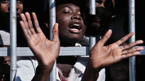 A migrant gestures from behind the bars of a cell at a detention centre in Libya, Tuesday 31 January ...