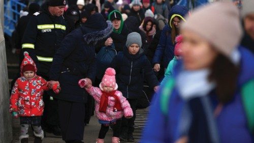 A woman walks with two kids, as they arrive by ferry after fleeing from Russia's invasion of ...