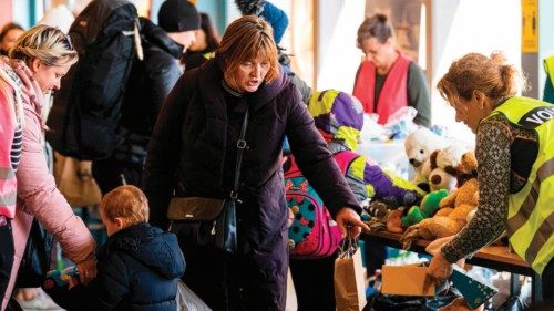 Volunteers distribute supply articles and information to Ukrainian refugees upon their arrival at a ...
