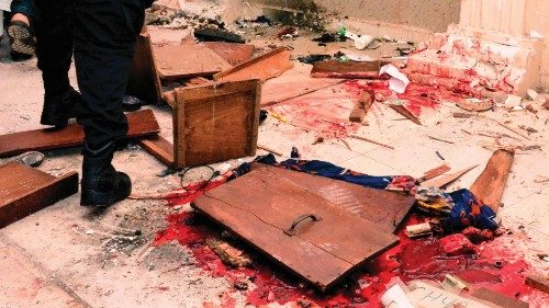EDITORS NOTE: Graphic content / A man walk past the blood the stained floor after an attack by ...