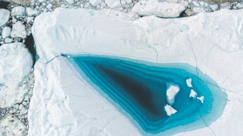 Picture taken on June 29, 2022 with a drone shows turquoise water in a large melt hole on the top of ...