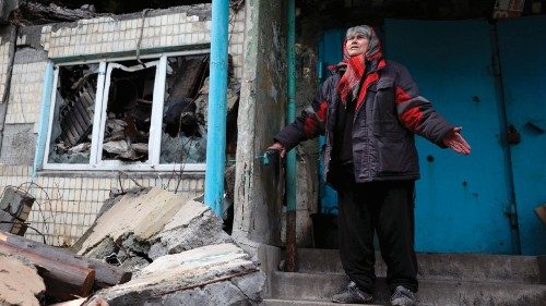 TOPSHOT - Local resident Ludmyla, 76, stands in front of a heavily damaged residential building in ...