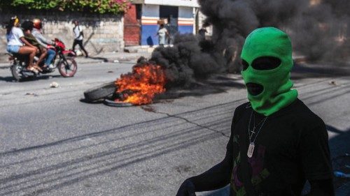 epa11192516 A hooded man is seen on the streets, in Port-au-Prince, Haiti, 01 March 2024, a day ...
