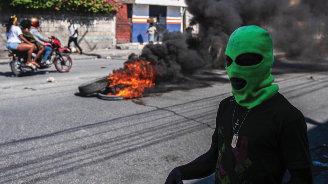 epa11192516 A hooded man is seen on the streets, in Port-au-Prince, Haiti, 01 March 2024, a day ...