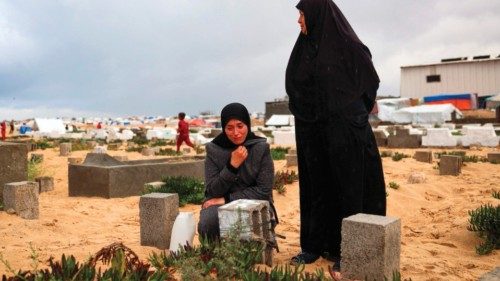 A woman cries over the grave of a loved one at the start of the Eid al-Fitr festival, marking the ...