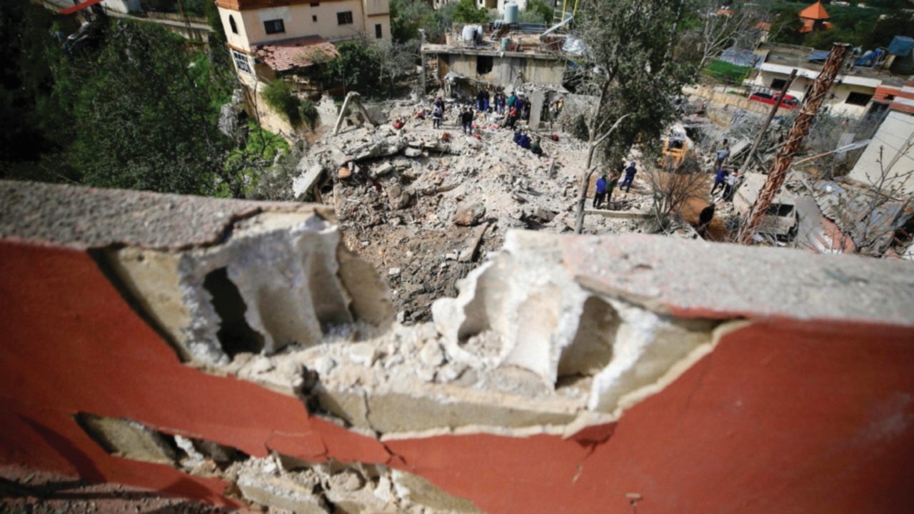 epa11246437 People inspect the damage at the site of an airstrike in Habbariyah, southern Lebanon, ...