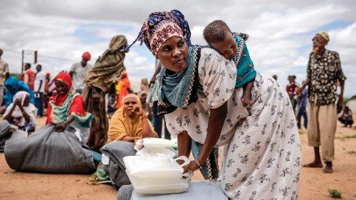 A woman who have been displaced from her home due to heavy floods carry her baby on the back while ... A woman who have been displaced from her home due to heavy floods carry her baby on the back while ...