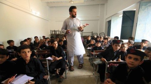 epa11591018 A teacher works with Pakistani school children during a class ahead of the International ...