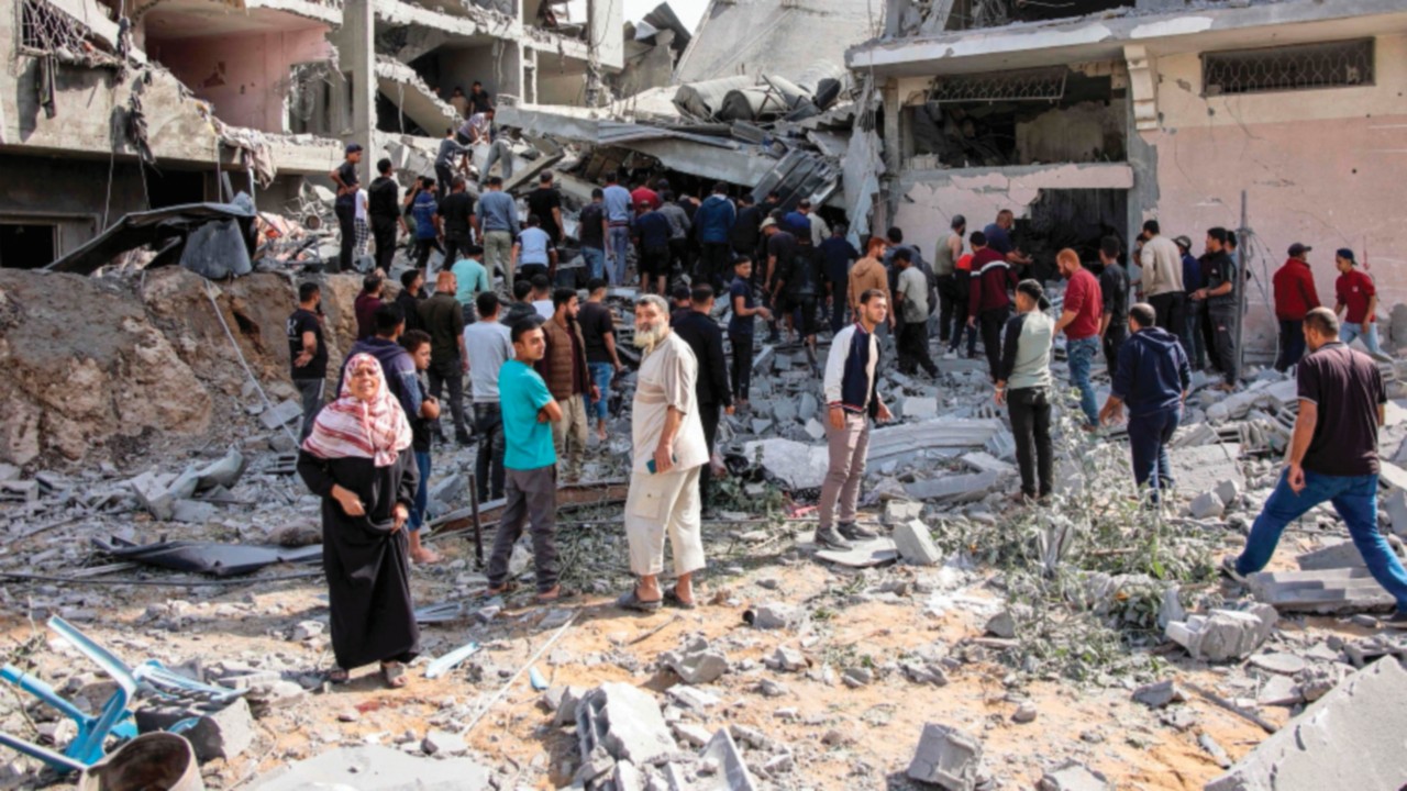People gather to search for survivors and victims through the rubble following Israeli bombardment ...